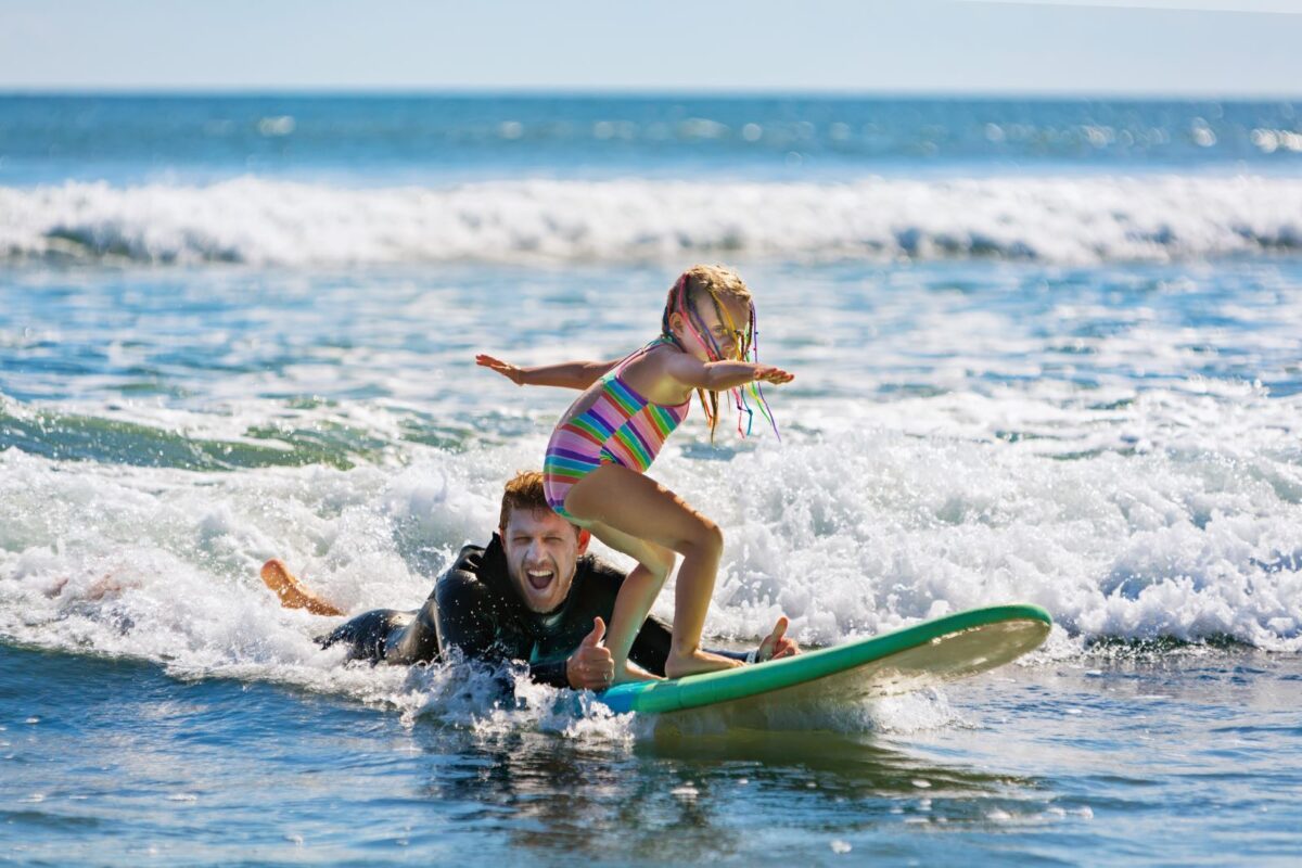 Little girl getting a surfing lesson